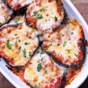 Eggplant casserole is served in a white baking dish.