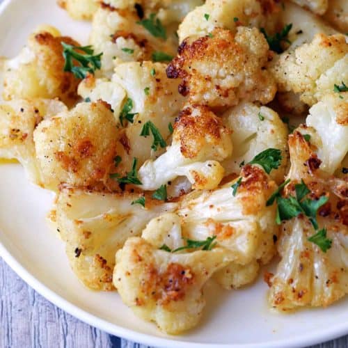Roasted cauliflower is served on a white plate.