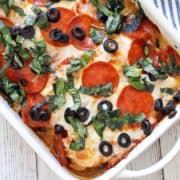 Pizza chicken is served in a white baking dish with a striped napkin.