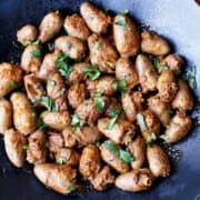 Chicken hearts are served on a dark plate.