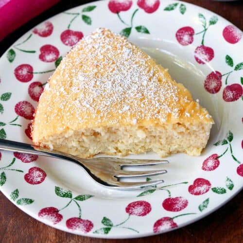 Keto coconut cake is served on a plate with a fork.
