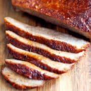 Oven brisket, sliced and served on a wooden cutting board.