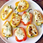 Stuffed mini peppers are served on a white plate.