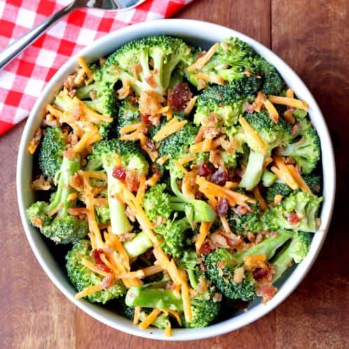 Keto broccoli salad is served in a white bowl with a napkin and a spoon.