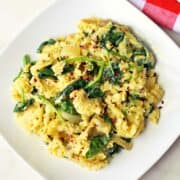 Spinach and eggs are served on a white plate with a napkin.