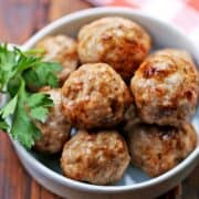 Pork meatballs are served in a white bowl.