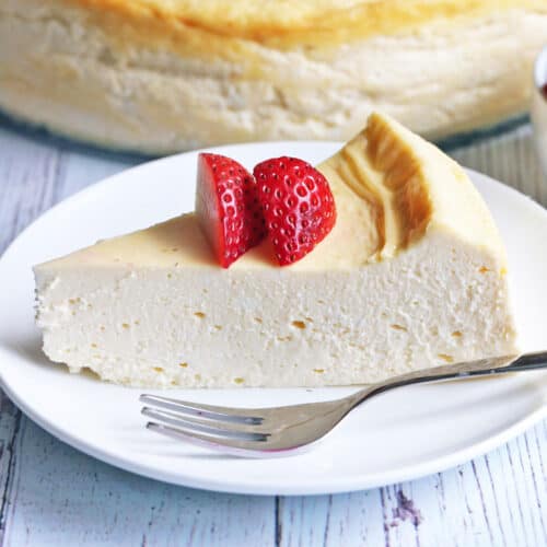 A slice of keto cheesecake topped with strawberries.