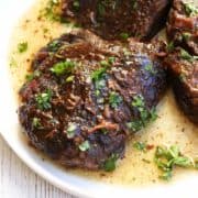 Beef cheeks are served on a white plate.
