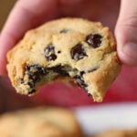 A hand is holding a keto chocolate chip cookie.