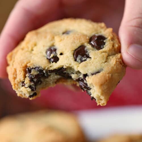 A hand is holding a keto chocolate chip cookie.
