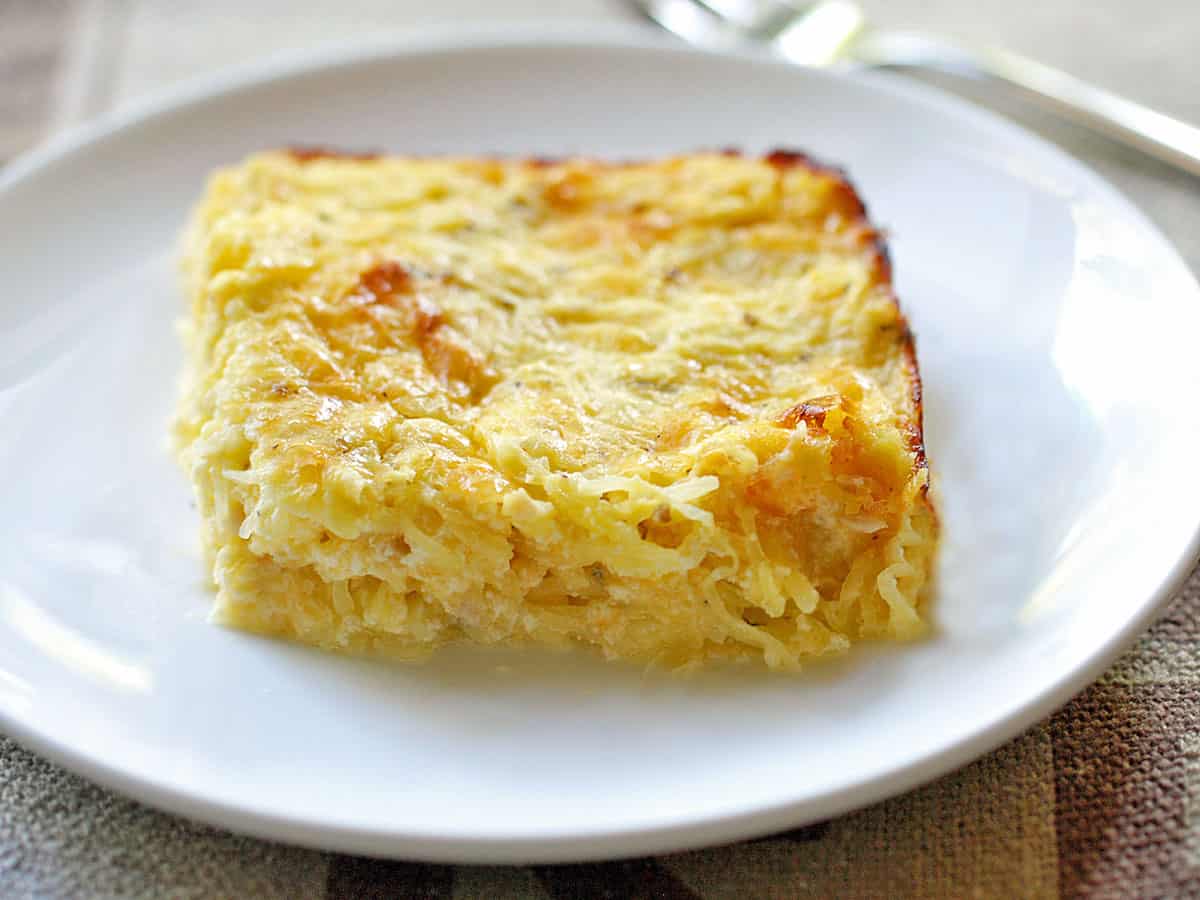 A square of spaghetti squash casserole is served on a plate. 