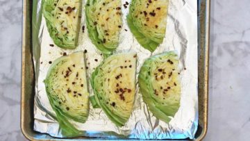 Seasoned cabbage on a baking sheet.