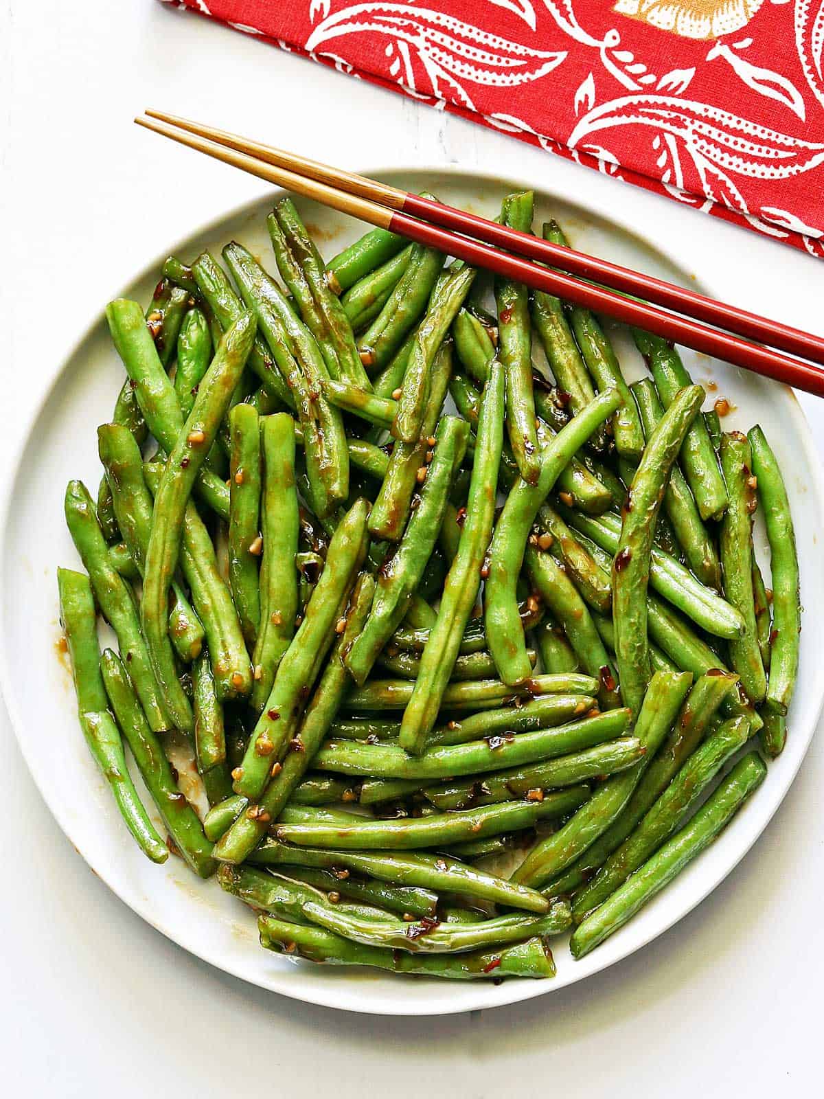 Chinese green beans are served with chopsticks. 