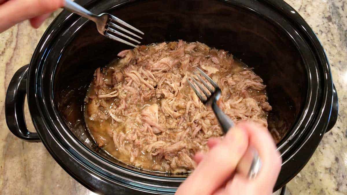 With two forks, shred the meat inside the slow cooker pan. 