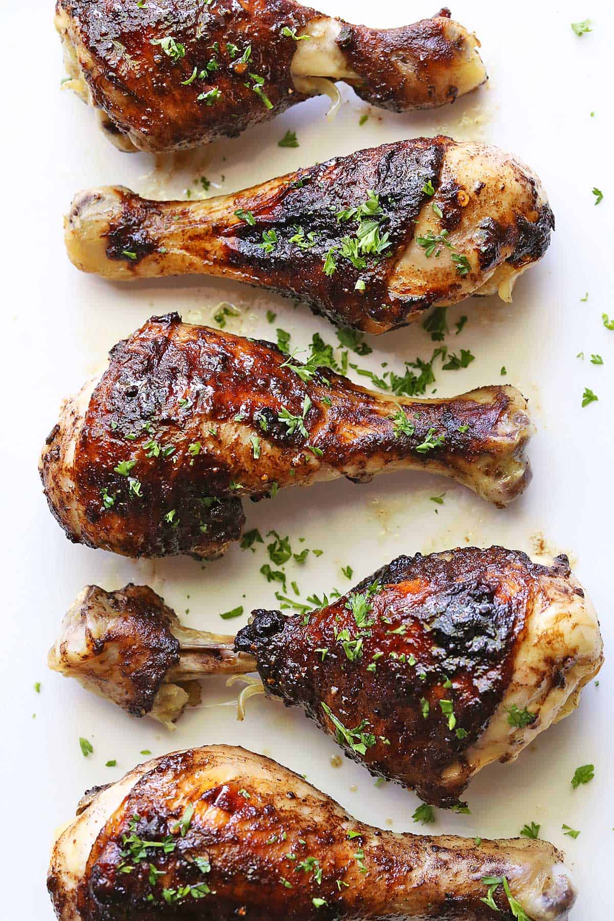 Jerk chicken is served on a white plate. 