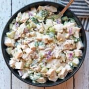 Leftover turkey salad is served in a dark bowl.