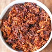 Pulled chicken is served in a white bowl.