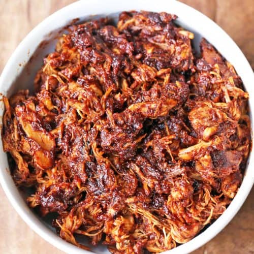 Pulled chicken is served in a white bowl.