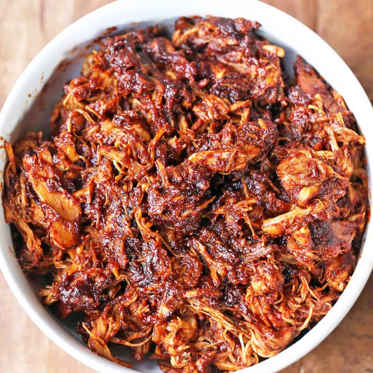 Pulled chicken is served in a white bowl.