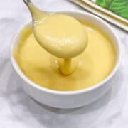 Blender hollandaise sauce is served with a spoon.