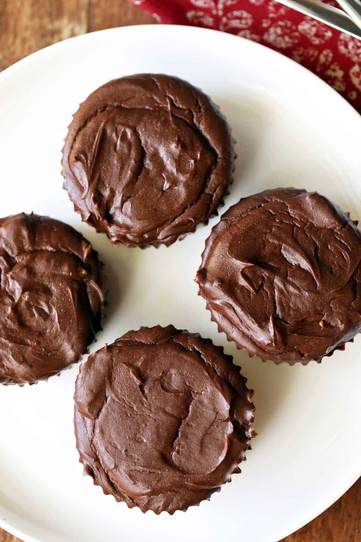 Four mini chocolate cheesecakes are served on a white plate.