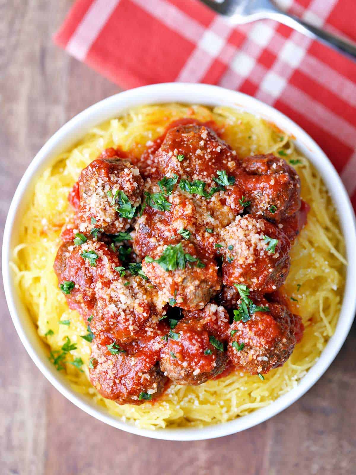 Spaghetti squash and meatballs are served in a white bowl. 