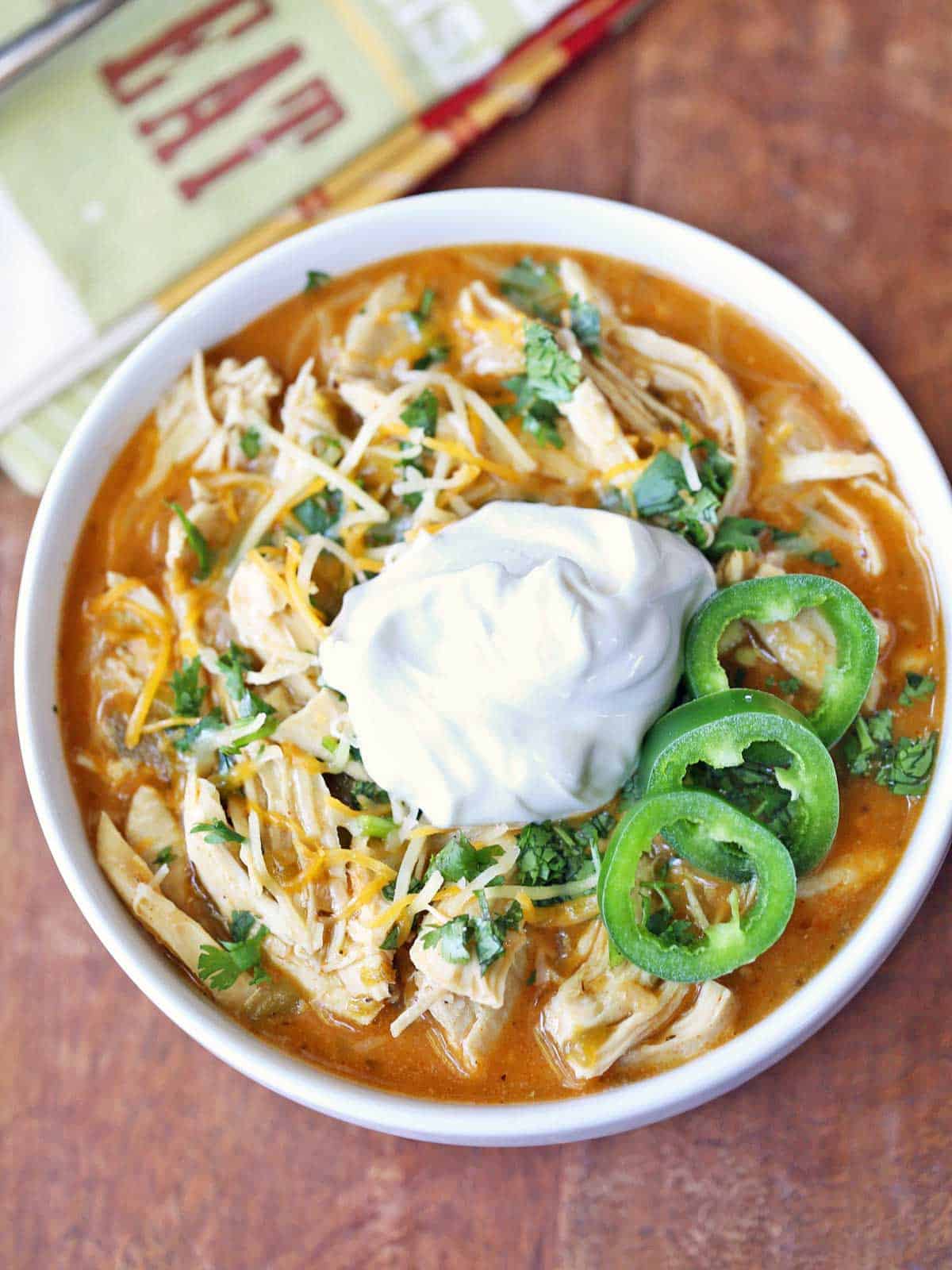 Chicken chili is served in a white bowl. 