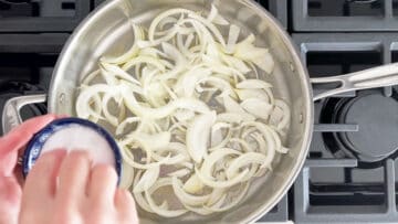 Salting the onions in the skillet.
