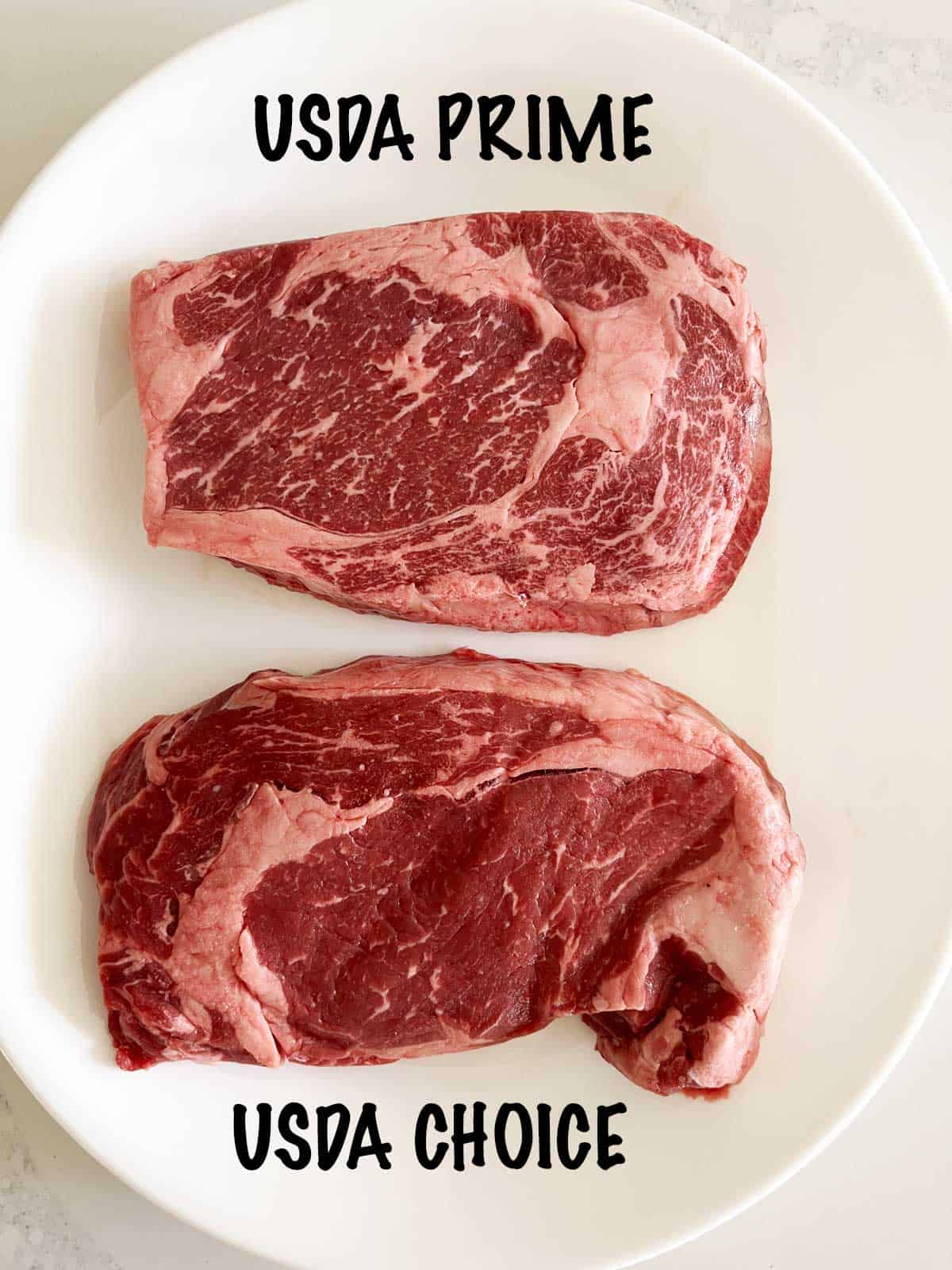 A prime-grade and a choice-grade ribeye steaks on a plate. 