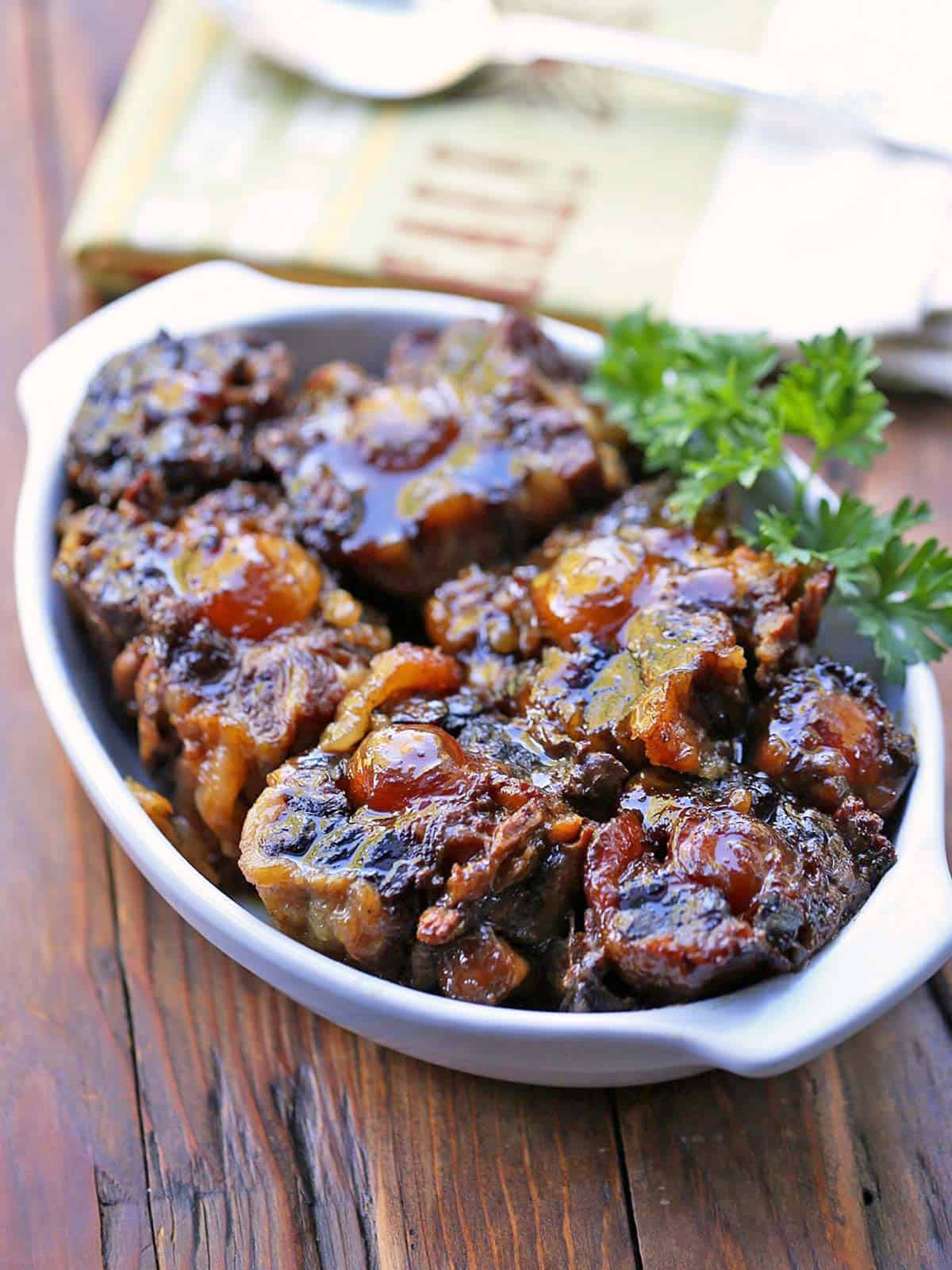 Slow cooker oxtail is garnished with parsley.