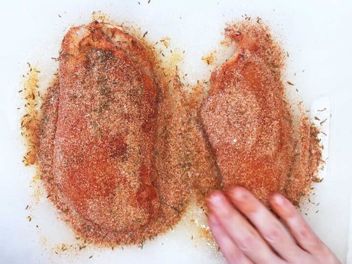Coating the chicken in spices.