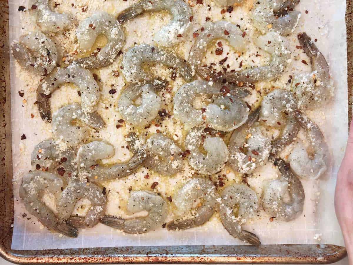 Seasoned shrimp on a baking sheet. 