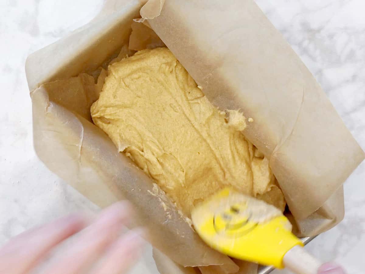 The batter is being smoothed out with a spatula.