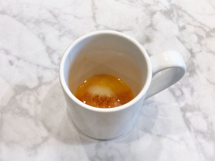 Hollandaise sauce ingredients in a cup.