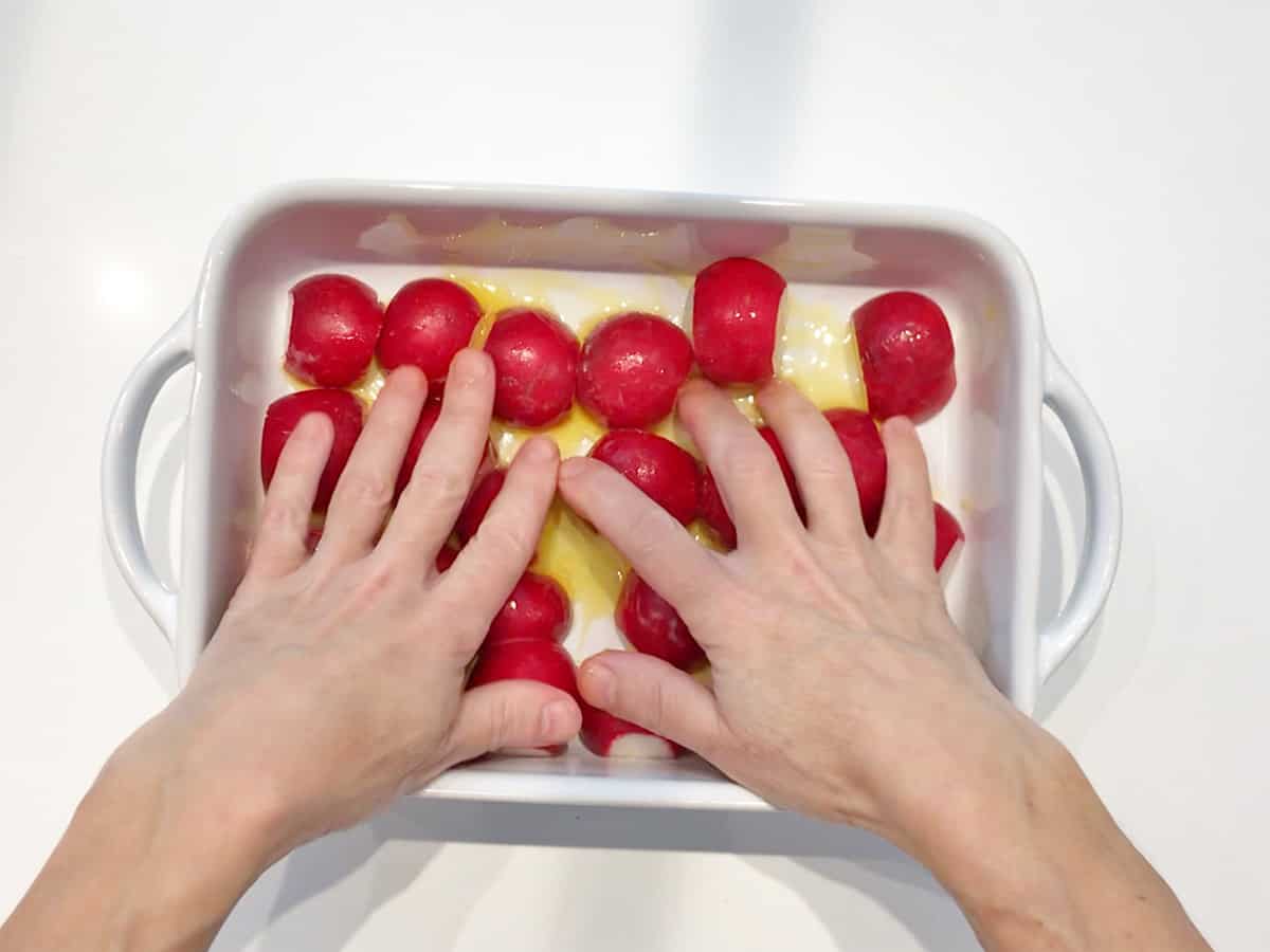 Coating the radishes in butter. 