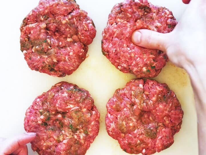 Making a dimple in the burger patties.