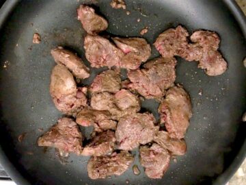 Cooking chicken livers in a skillet.