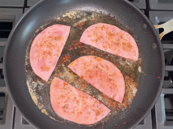Cooking first side of ham steaks.