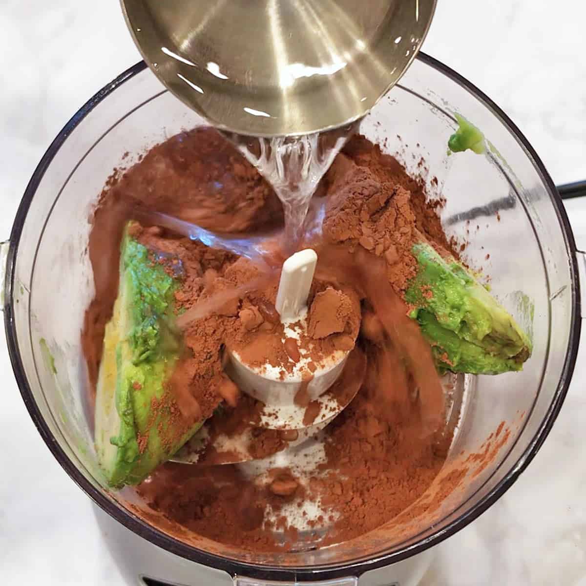 Adding water to the food processor.