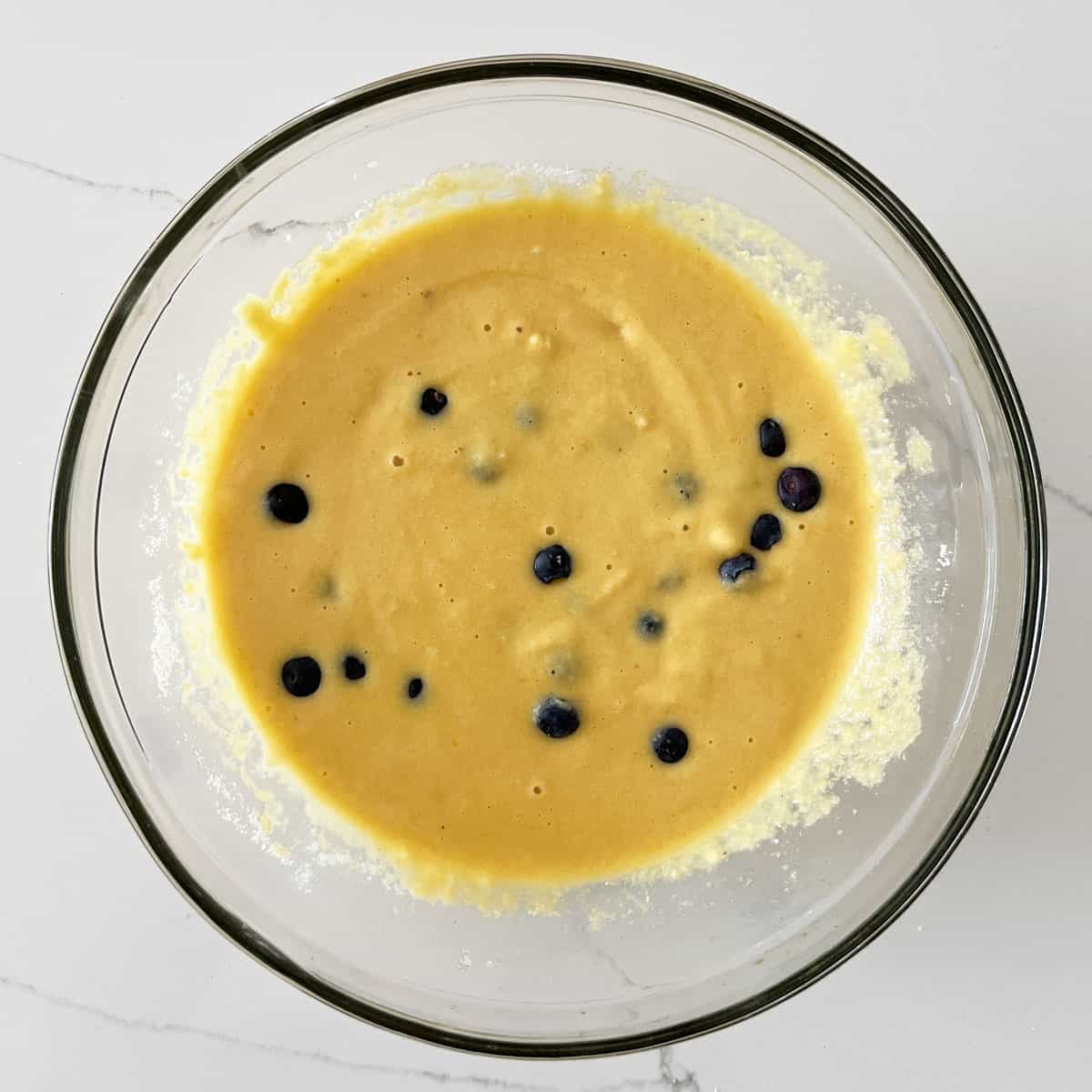 Adding blueberries to the batter.