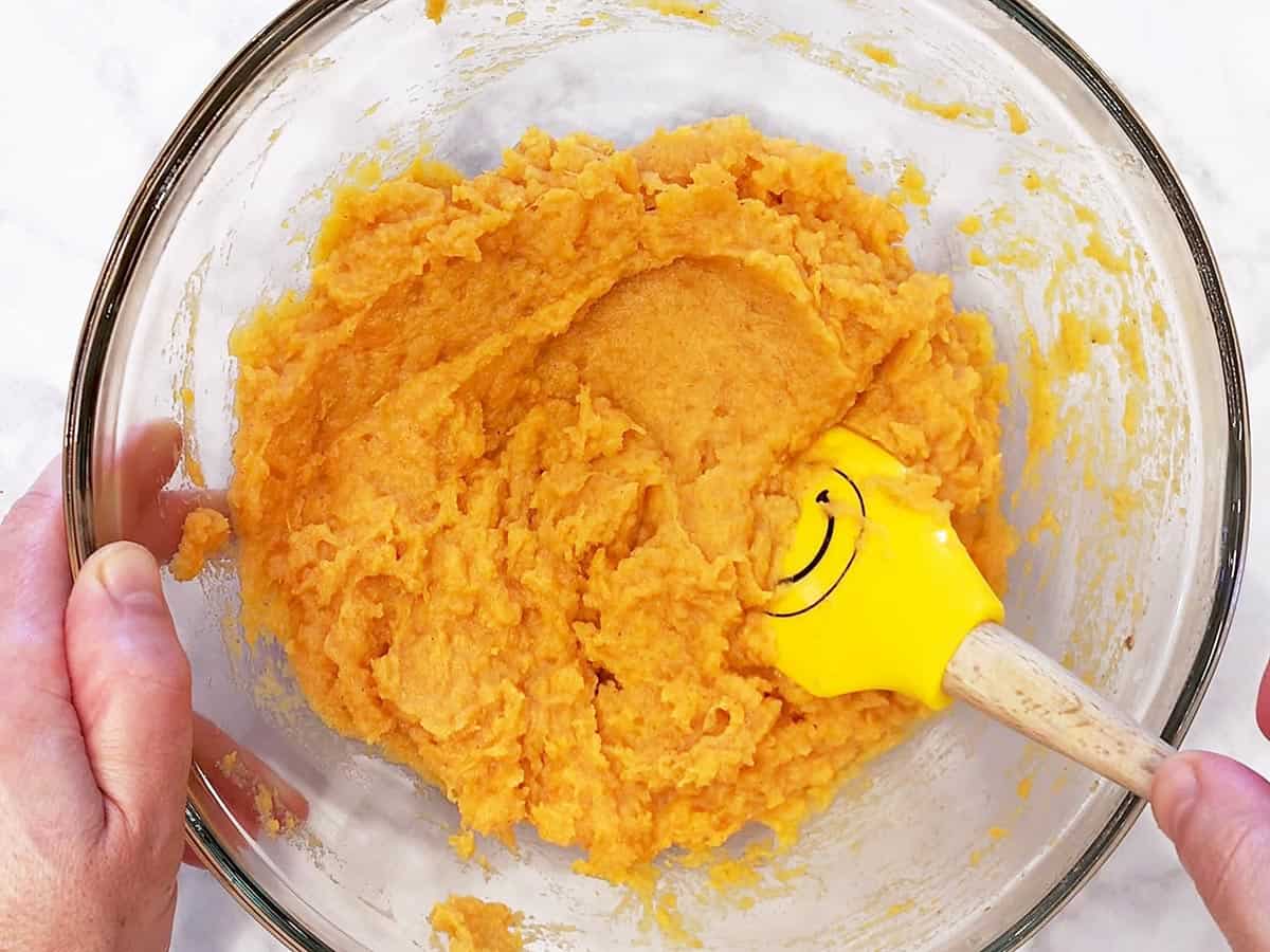 Mixing the mash with a rubber spatula.