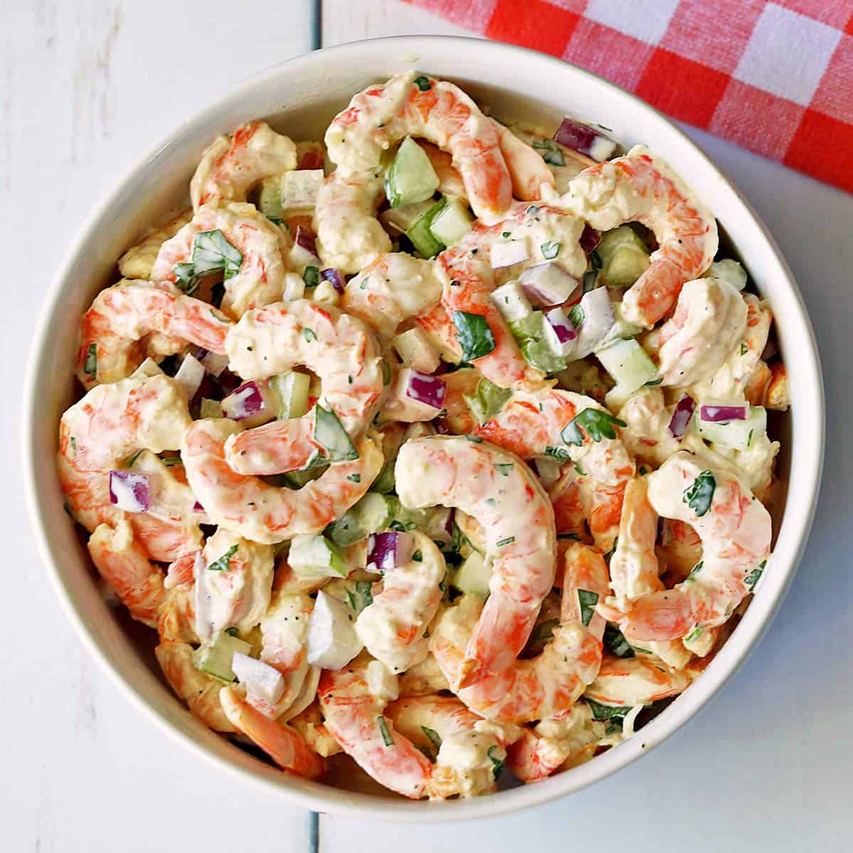 Shrimp salad is served in a white bowl.
