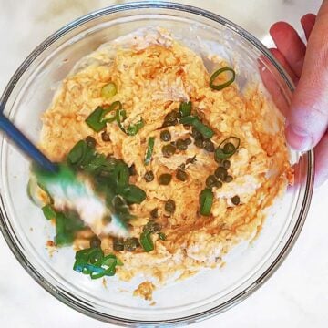 Adding capers and scallions.