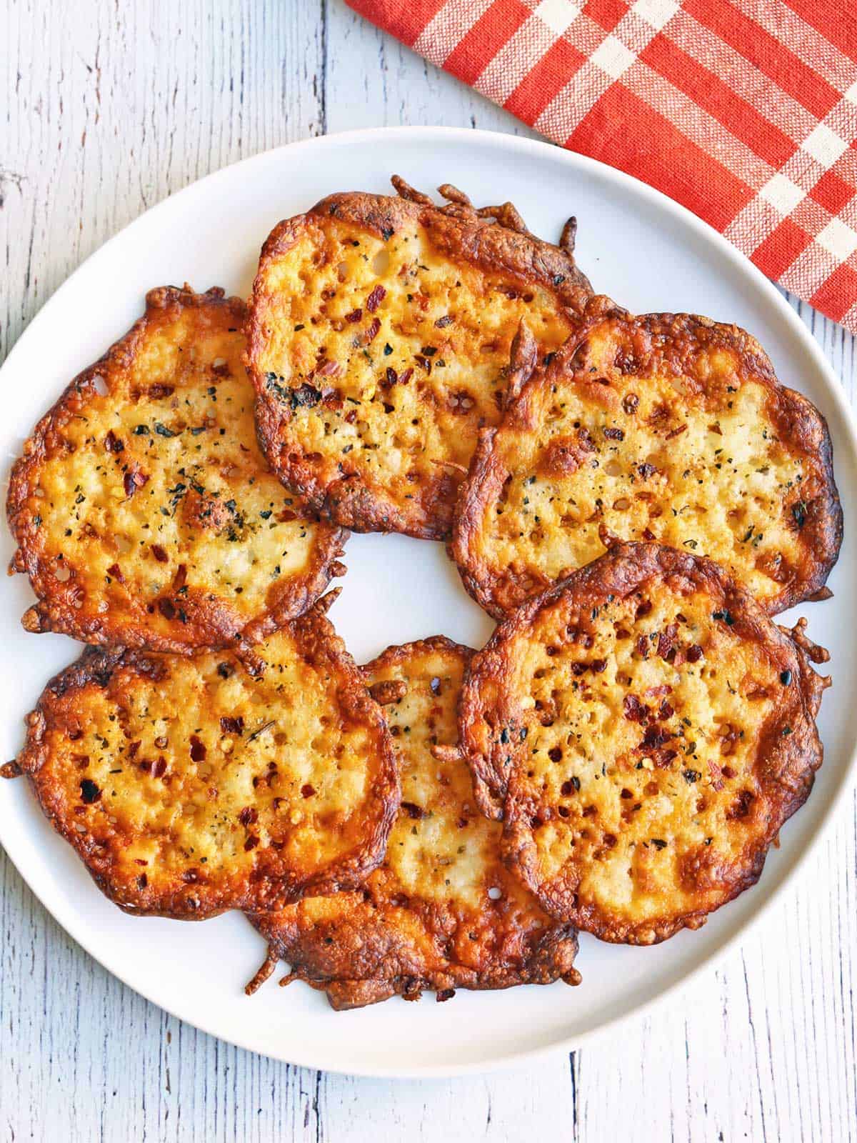 Cheese chips are served on a white plate.