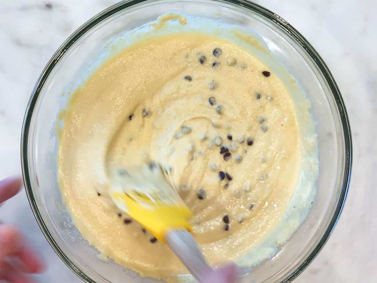 Adding chocolate chips to the batter.