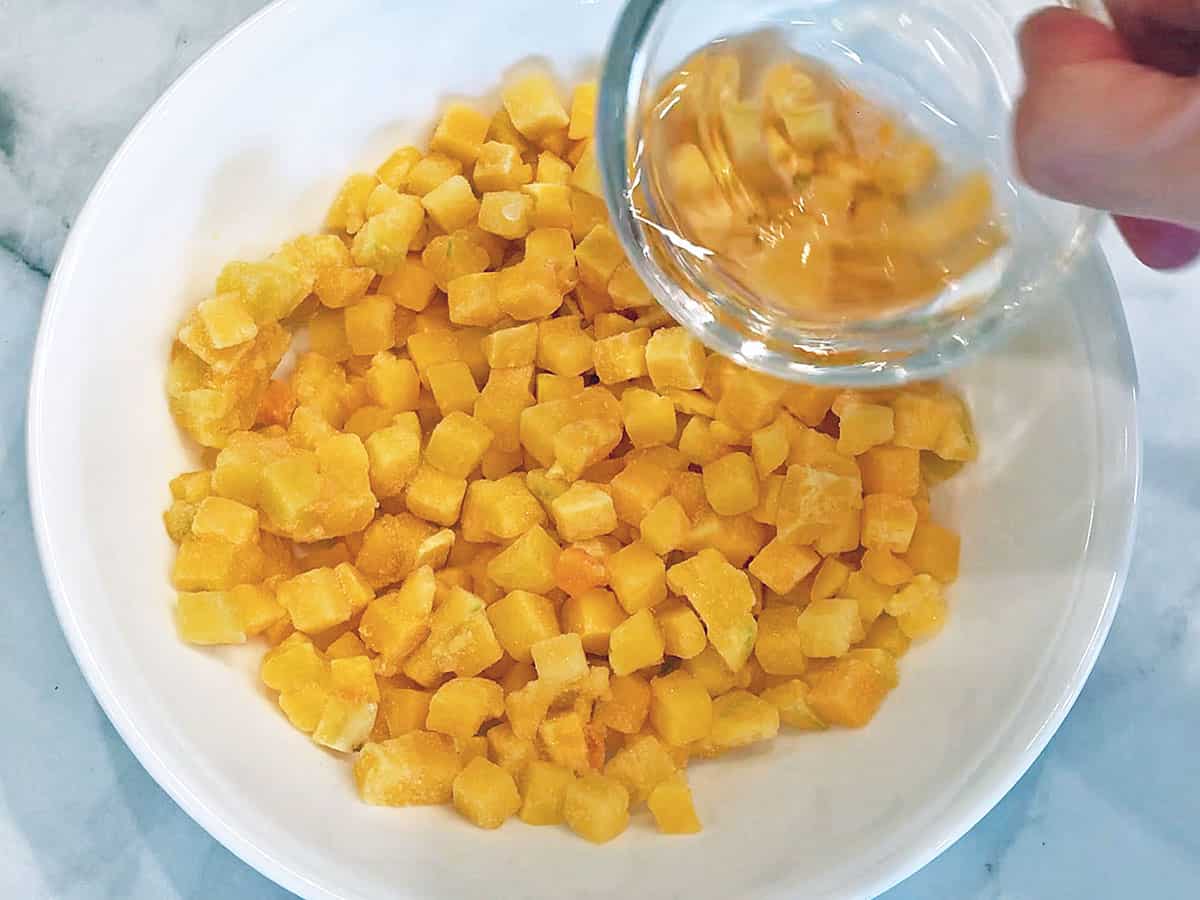 Adding water to the bowl with the squash.