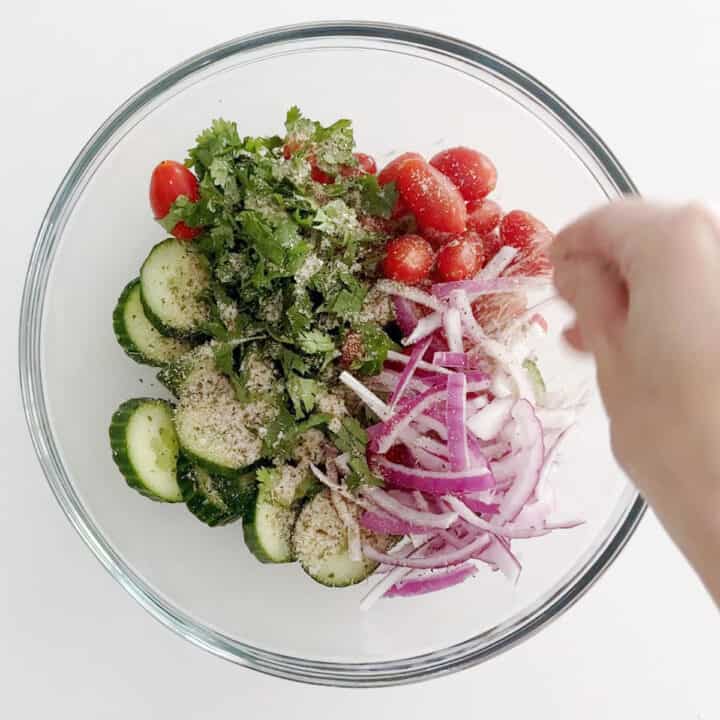 Adding spices to the salad.