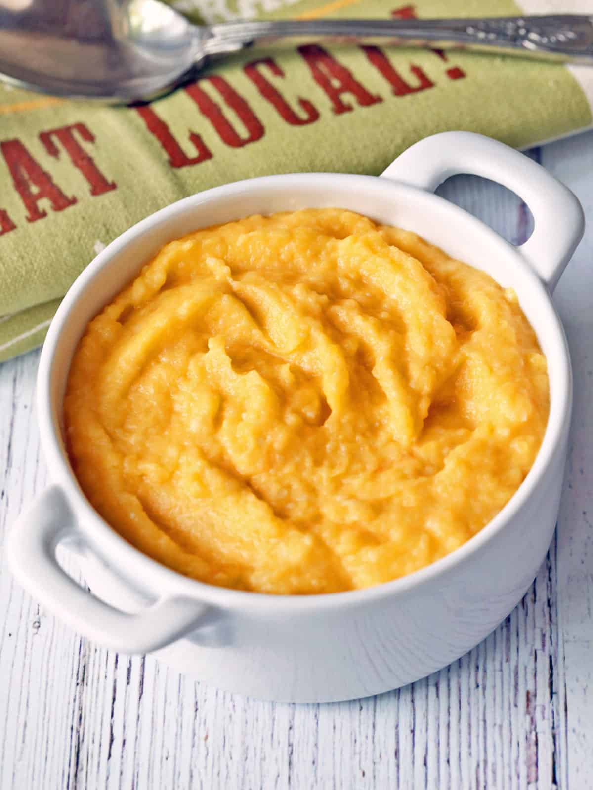 Mashed butternut squash is served in a white bowl.