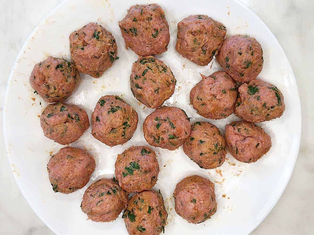 Shaped meatballs on a white plate.