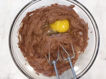 Adding an egg yolk to the mixture.